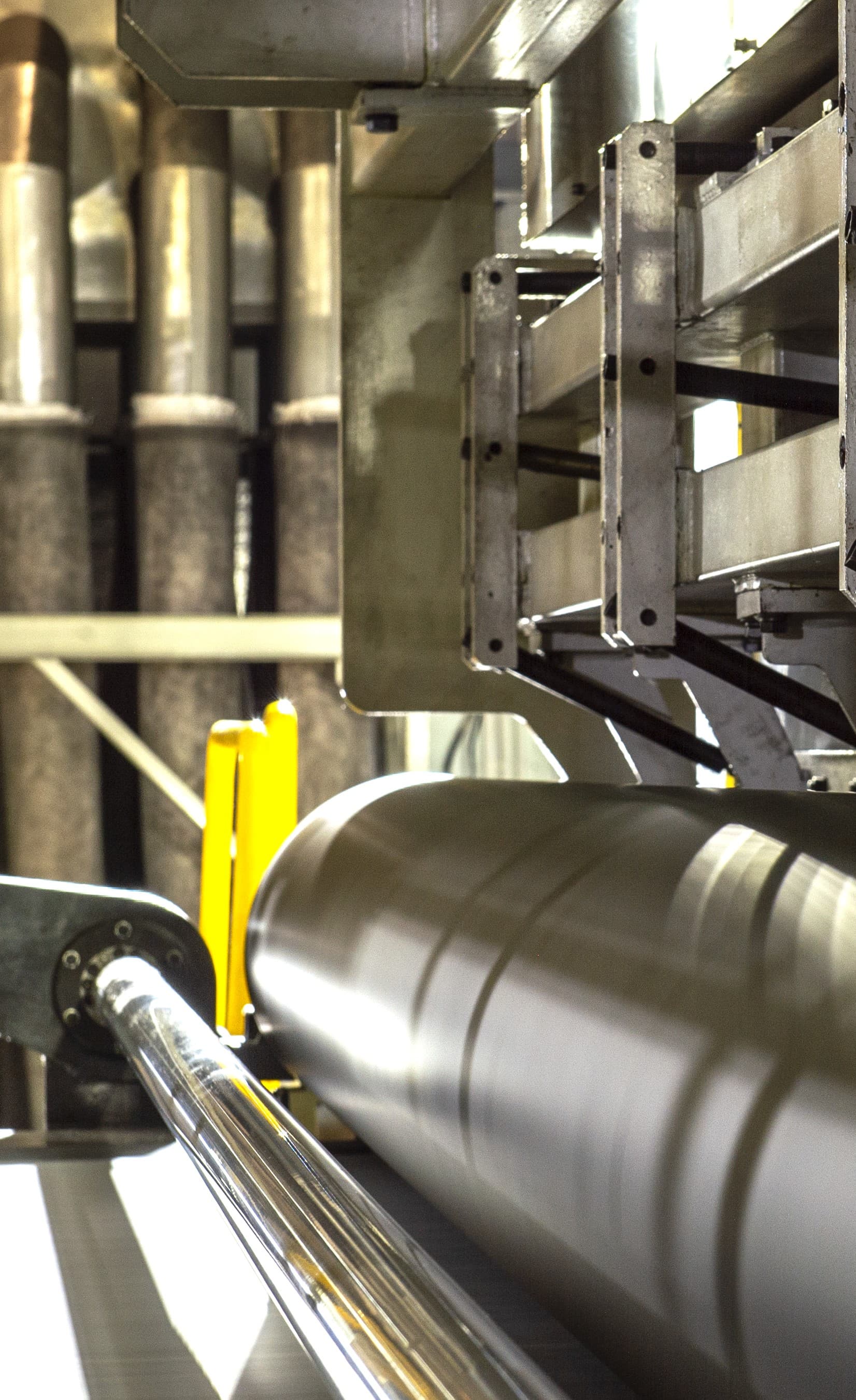 Heavy industrial manufacturing equipment with a large metal roller