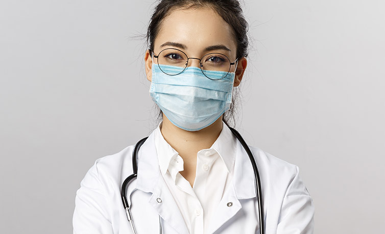 Female medical professional wearing a face mask and stethoscope