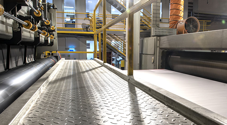 Elevated walkway and railings beside a large manufacturing machine
