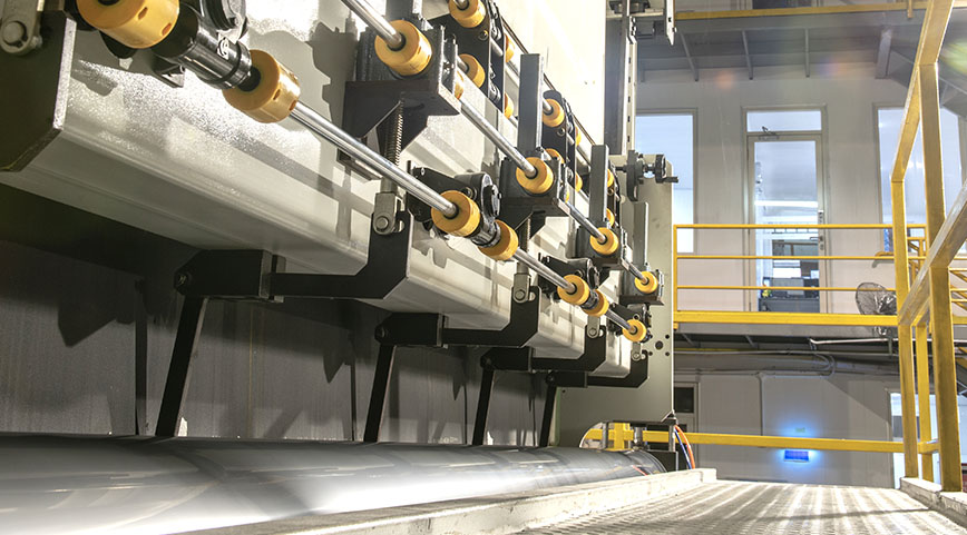 Detailed view of machinery components and rollers in a manufacturing plant