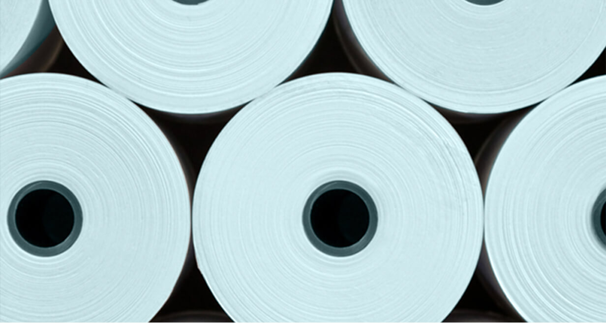 Stack of large white nonwoven fabric rolls viewed from the end